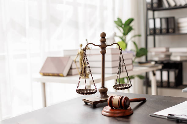 Justice statue, gavel, with LAW Justice lawyers having team meeting at law firm background. Concepts of Law and Legal services.